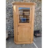 An antique pine standing corner cupboard, 191cm high x 104cm wide.