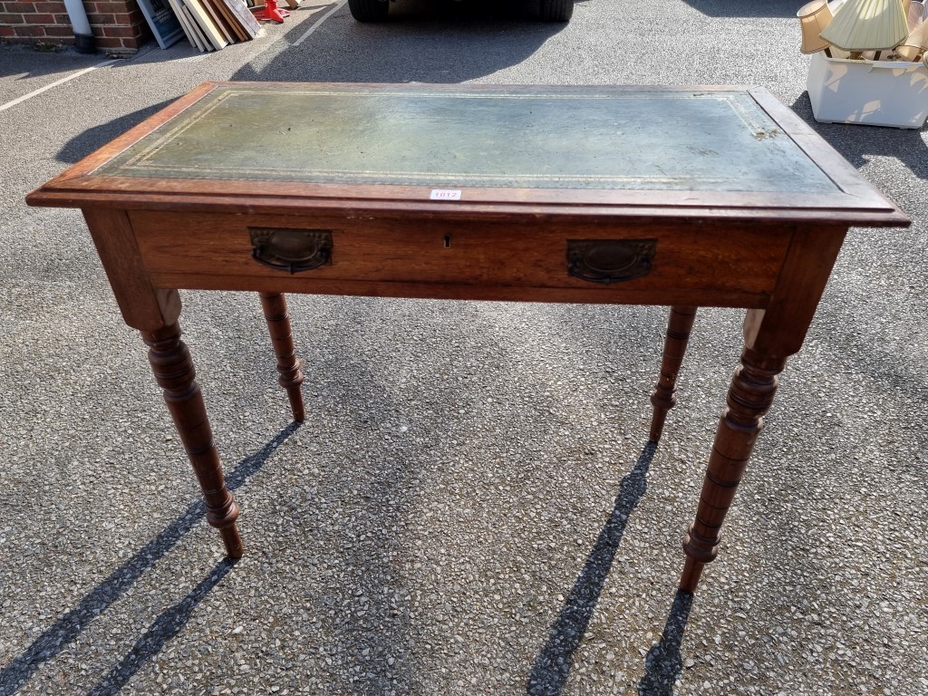 An antique oak side table, having leather top, 72cm high x 92cm wide.