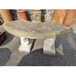 A curved reconstituted stone bench, having squirrel supports, 103cm wide x 48cm high.