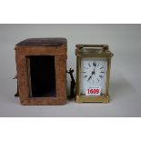 An antique brass carriage timepiece, with leather travelling case, height including handle 15cm,
