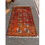 A Persian rug, having ten medallions to central field with floral borders, on orange ground, 158cm x