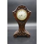 An Art Deco carved mahogany balloon timepiece, 31.5cm high.