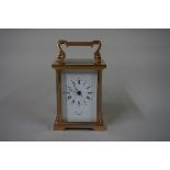 A small brass carriage timepiece, height including handle 14cm, with winding key.