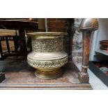 A large antique brass jardiniere, embossed with classical decoration, 32cm high.