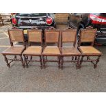 Five carved oak and cane dining chairs.