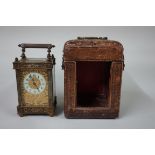An antique brass carriage timepiece, with associated leather travelling case, height including