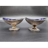 A pair of Victorian silver oval pedestal salts, having chased decoration, by Charles Stuart