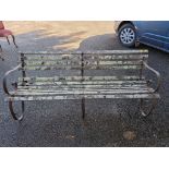 A garden bench, having wrought iron supports, 183cm wide.