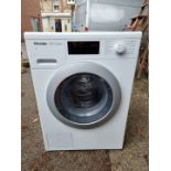 A Miele W1 classic washing machine, 84.5cm high x 60cm wide, with instruction manual.
