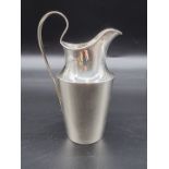 A Continental white metal milk jug, maker CBS, 17cm high.