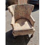 An old floral upholstered armchair.