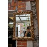 An old carved giltwood wall mirror, 65 x 48cm.
