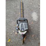 A Ryobi petrol hedge trimmer.