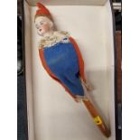 An early 20th century bisque head musical rattle doll, in blue and red jester costume, head