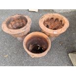 A pair of terracotta urns, (cracked); together with another terracotta pot.