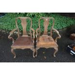 A pair of antique elbow chairs.