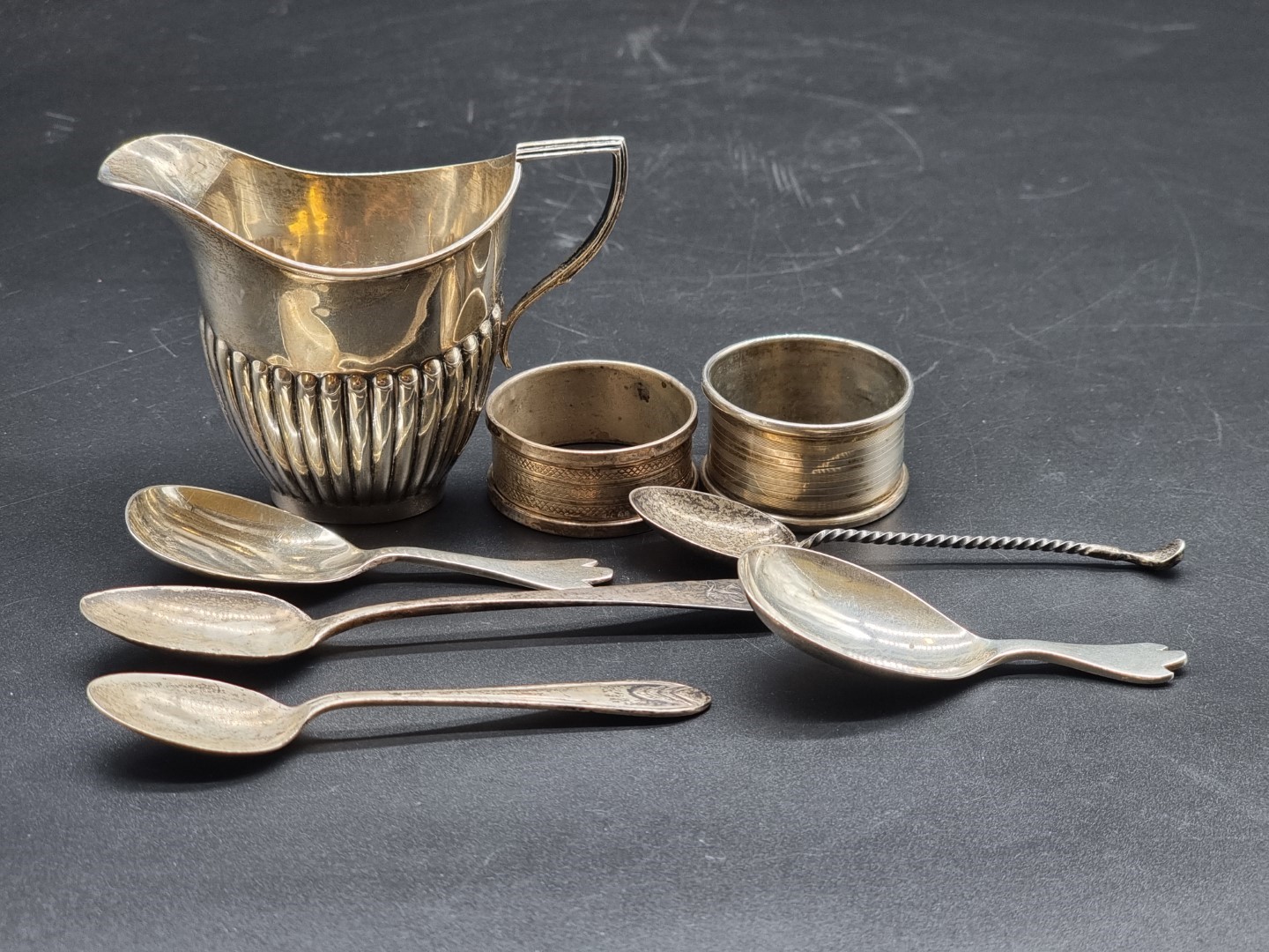 A mixed group of silver, comprising: a cream jug; two caddy spoons; a novelty golf club teaspoon;