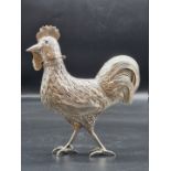 A continental white metal cockerel, the hinged head revealing a pierced cover, 344g, 20.5cm high.