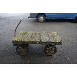An antique wooden cart, with iron pull bar, 122cm long x 70cm wide x 47cm high.