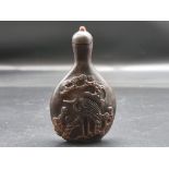 A Chinese relief carved horn snuff bottle and stopper, possibly rhinoceros, 19th century, 9cm high.