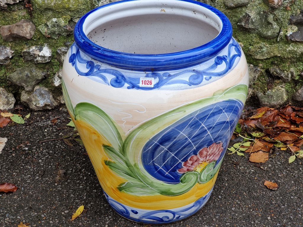 A large painted terracotta urn, 51cm high x 44cm wide; together with another blue glazed urn and