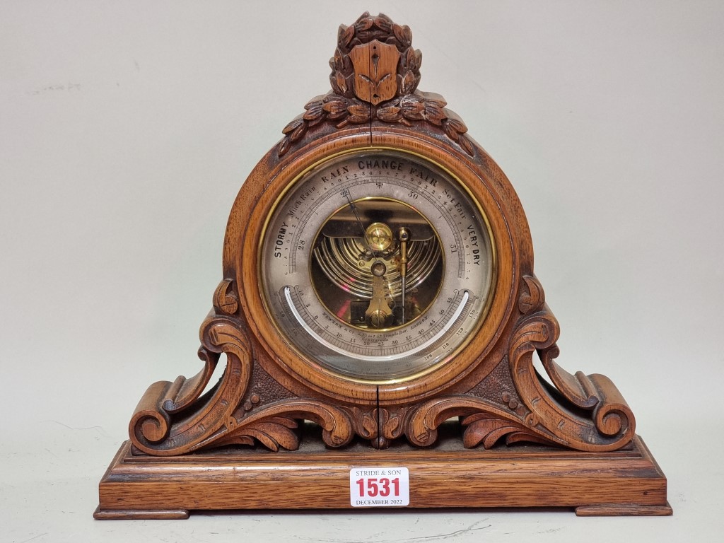 A Victorian carved walnut aneroid barometer, the silvered dial inscribed 'Newton & Co,...,