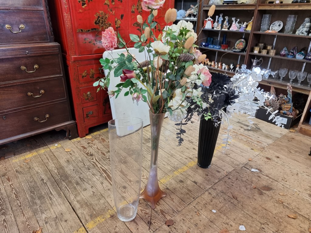 Three oversized glass vases, largest 70cm high; together with two displays of silk flowers.