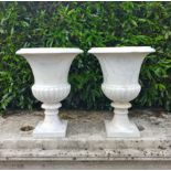 A similar pair of carved white marble urns