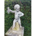 A lead figure of a putto holding a bunch of grapes