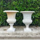 A similar pair of carved white marble urns