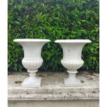 A similar pair of carved white marble urns