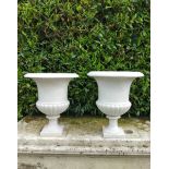 A pair of carved white marble urns