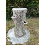 A composition stone faux bois tree trunk planter