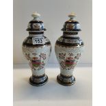 A pair of Porcelain vases in Chinese Export style. Lid on one of the vases has a couple of chips