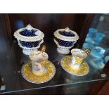 A pair of continental urns and a pair of cup and saucers