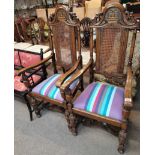 Pair of oak carved bergère dining chairs with Crown decorated backs