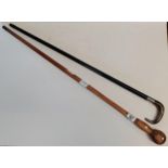 x2 Walking sticks, (1) Tapered ebonised shaft with silver repousse mounts and horn handle. (2)