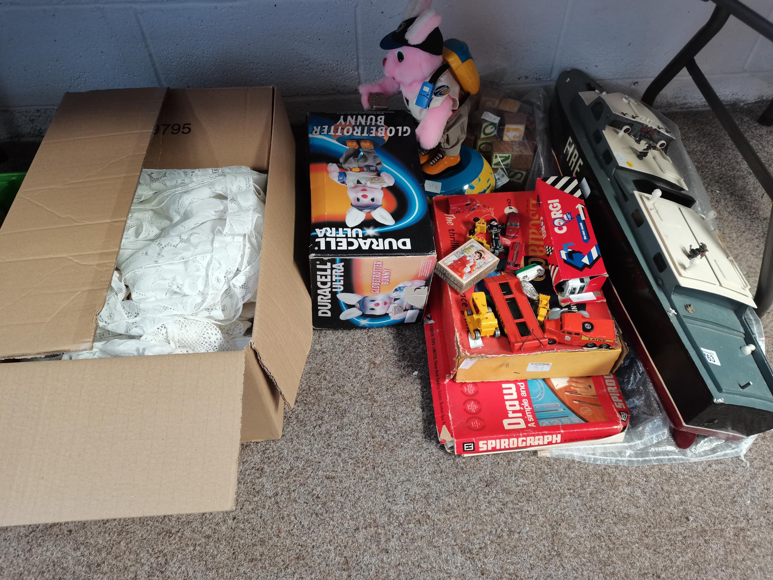 Large Box of linen, Fire Boat, Duracell Globetrotter Bunny and assorted toys