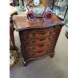 Walnut and mahogany serpentine front bachelors chest having brush slide above four graduated drawers