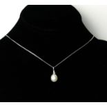 A 9CT WHITE GOLD PENDANT WITH A SUSPENDED WHITE CULTURED PEARL AND DIAMOND BALE Set with a tapered