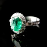 AN 18CT WHITE GOLD, EMERALD AND DIAMOND CLUSTER RING The central emerald surrounded by round