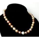 A STRING OF FRESHWATER CULTURED PEARLS IN SHADES OF WHITE, PEACH, PALE AND DARK PINK Fastened with a
