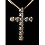 A 9CT GOLD AND ROUND BRILLIANT CUT DIAMOND CROSS SUSPENDED FROM A 9CT GOLD CHAIN. (approx diamond