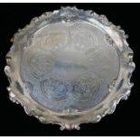 A VICTORIAN SILVER CIRCULAR SALVER With scalloped edge and fine engraved decoration, on scrolled