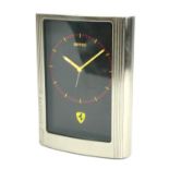 FERRARI, A STAINLESS STEEL BEDSIDE ALARM CLOCK, Rectangular form with black dial and ferrari horse