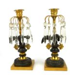 A PAIR OF EARLY 19TH CENTURY BRONZE ORMOLU CANDLESTICKS Classical form with acanthus leaf to