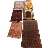 A COLLECTION OF SEVEN SMALL MIDDLE EASTERN RUGS To include two prayer rugs. (largest 179cm x