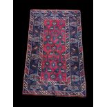 A TURKISH WOOLLEN RUG The central geometric field contained within running borders. (125cm x