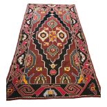 A LARGE TURKISH KILIM RUG With floral lozenges on a plum ground. (207cm x 152cm) Condition: good