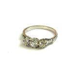 A VINTAGE WHITE METAL AND DIAMOND THREE STONE RING Graduated round cut stones (size P). (approx
